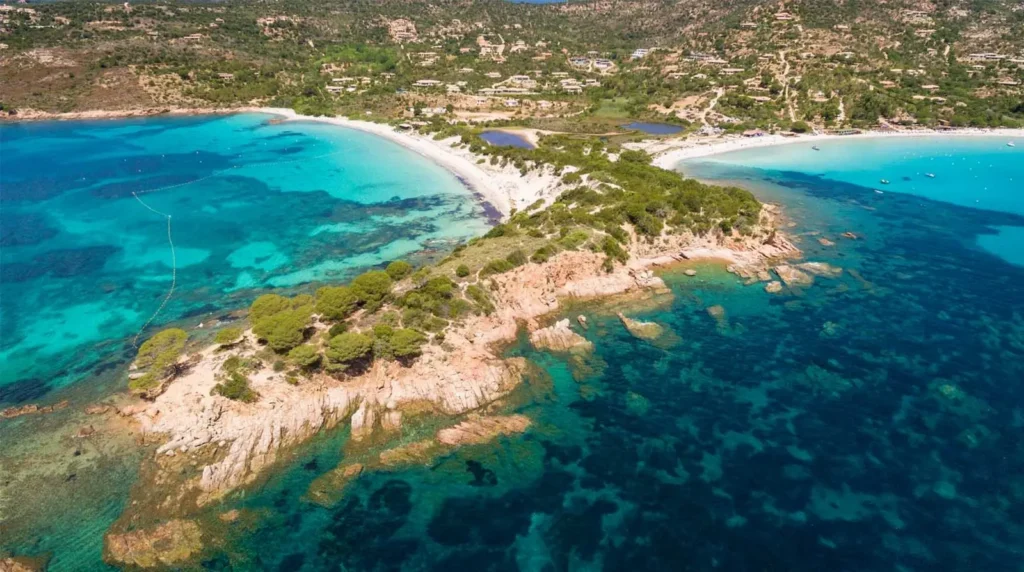 Vue aérienne d'une presqu'île bordée de plages de sable blanc et d'eau turquoise en Corse
