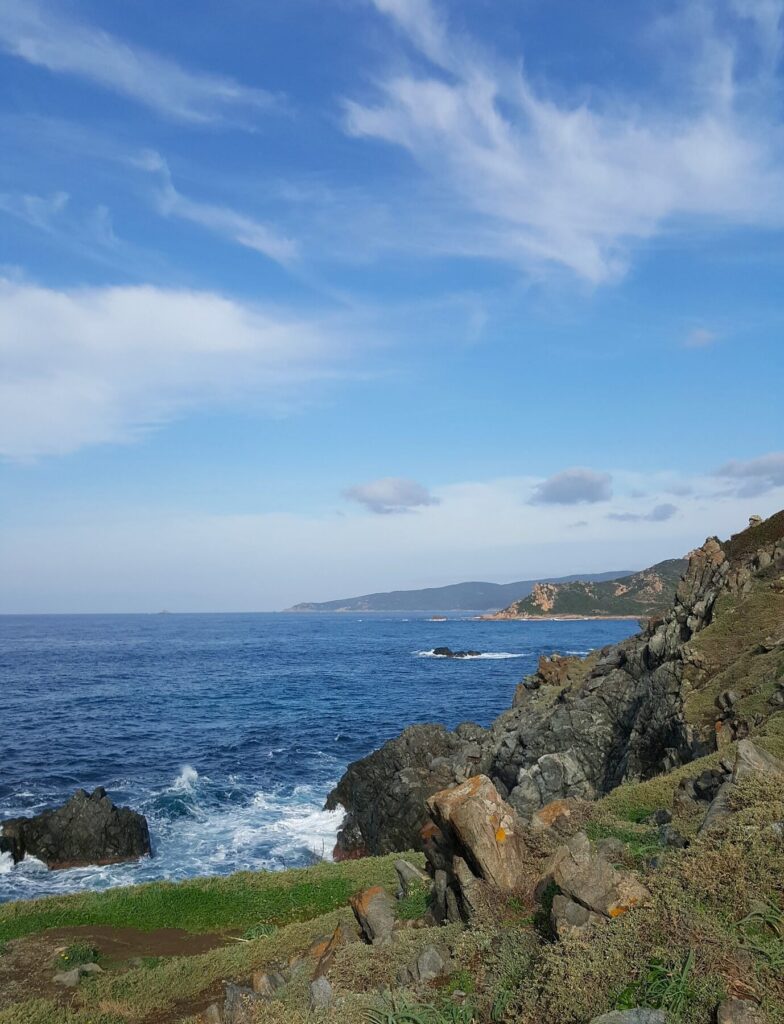 Photographie captivante des paysages côtiers corses, montrant une côte rocheuse sous un ciel bleu ensoleillé à Ajaccio, idéale pour ceux qui aiment la nature et l’océan. Une photographie pour la page Camping Corse bord de mer à Ajaccio en Corse du sud