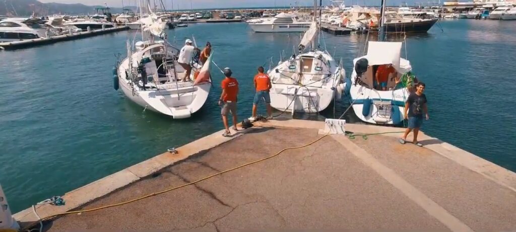 ambiance-estivale-au-port-de-plaisance-en-corse Une journée animée d'été au port de plaisance en Corse avec des voiliers et une mer turquoise, évoquant détente et aventure.