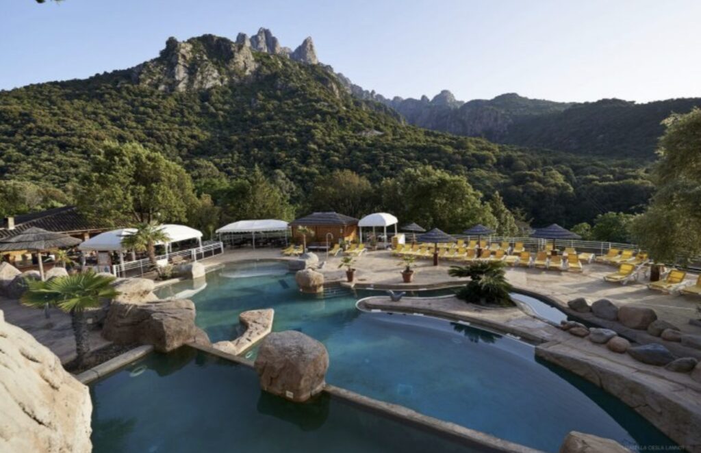 detente-au-bord-de-la-piscine-dans-un-cadre-naturel Piscine de luxe entourée de montagnes majestueuses et de palmiers, offrant un havre de paix idéal pour relaxation et connexion avec la nature.