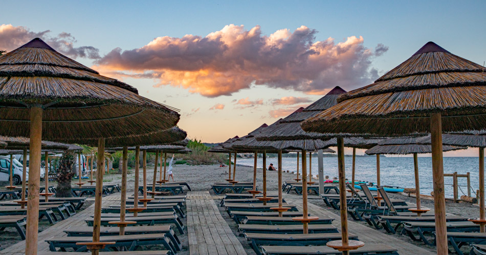 plage_parasol_ombre_chaises_longues_mer_soleil_coucher