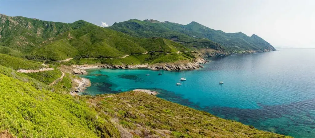 quelles-sont-les-3-plus-belles-plages-de-corse-1024x449 Vue aérienne d'une baie turquoise et de bateaux au mouillage en Corse