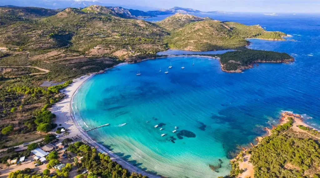 Vue aérienne d'une baie turquoise et de bateaux au mouillage en Corse
