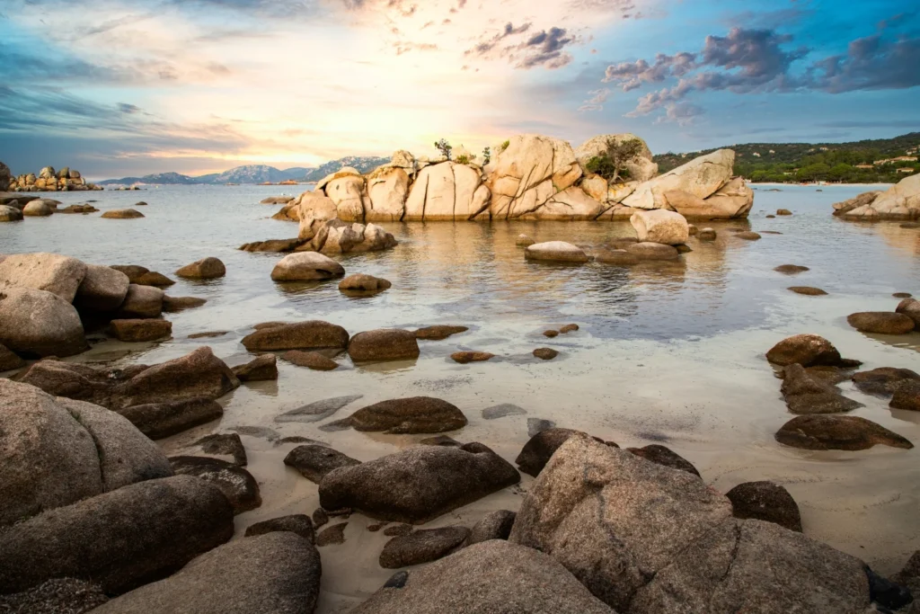 Plage de Palombiagga Rochers granitiques baignés par une eau turquoise à la plage de Palombaggia au coucher du soleil.