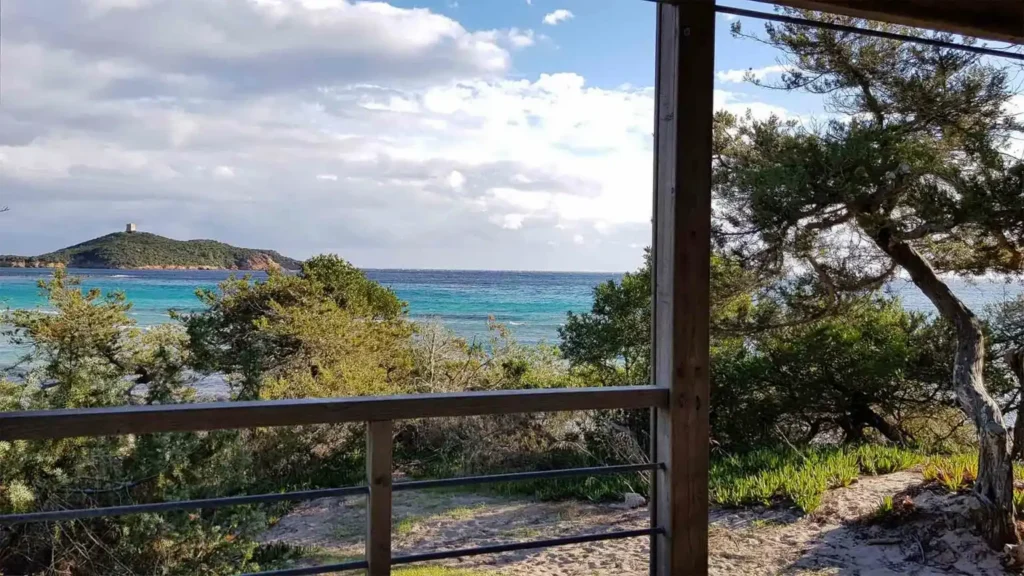 Chalet_dune_plan_mer-camping-villata Vue sur la mer turquoise et la tour génoise d'Isola di Cavallo (Pinarello) depuis la terrasse en bois d'un chalet de la dune au Camping Villata.